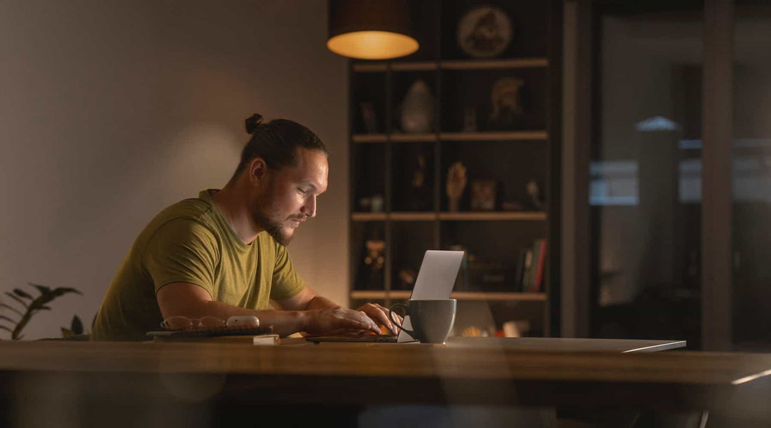 Homem concentrado a trabalhar num ambiente calmo e acolhedor, representando foco mental e equilíbrio emocional.