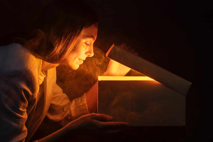 Pessoa a espreitar uma caixa de onde sai um luz misteriosa