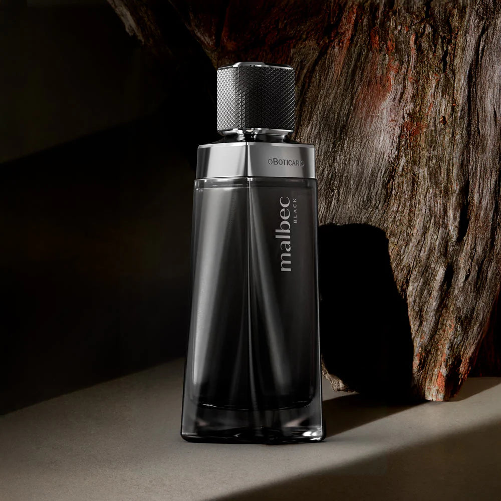 Malbec Black oBoticário frasco de perfume masculino junto a um tronco de madeira.