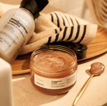 Açúcar Esfoliante Nativa SPA Baunilha de Madagáscar 200g com tampa aberta ao lado de toalha e colher