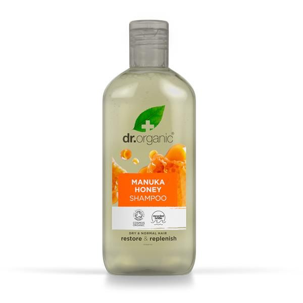 Frasco amarelo translúcido de Champô Bio Mel de Manuka Dr. Organic, 265 ml, com tampa transparente e rótulo laranja.