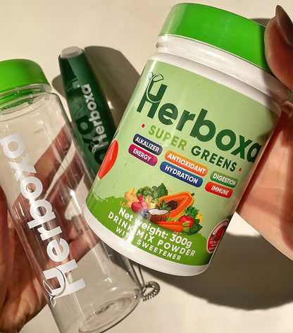 Embalagem Super Greens Herboxa 300g com shaker transparente, suplemento alimentar em pó com superalimentos verdes e probióticos.