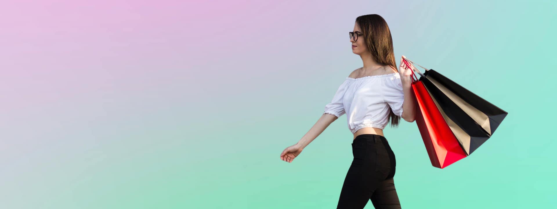 Senhora a caminhar com sacos de compras coloridos às costas e ar satisfeito